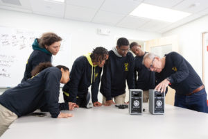 Innovative Panthers Club students look at the Roar Bluetooth Wireless Speaker with Tom DeVesto